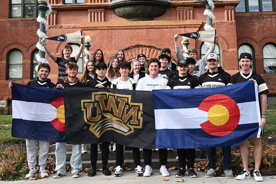一群来自科罗拉多的学生举着两面科罗拉多旗和一面NWU旗.